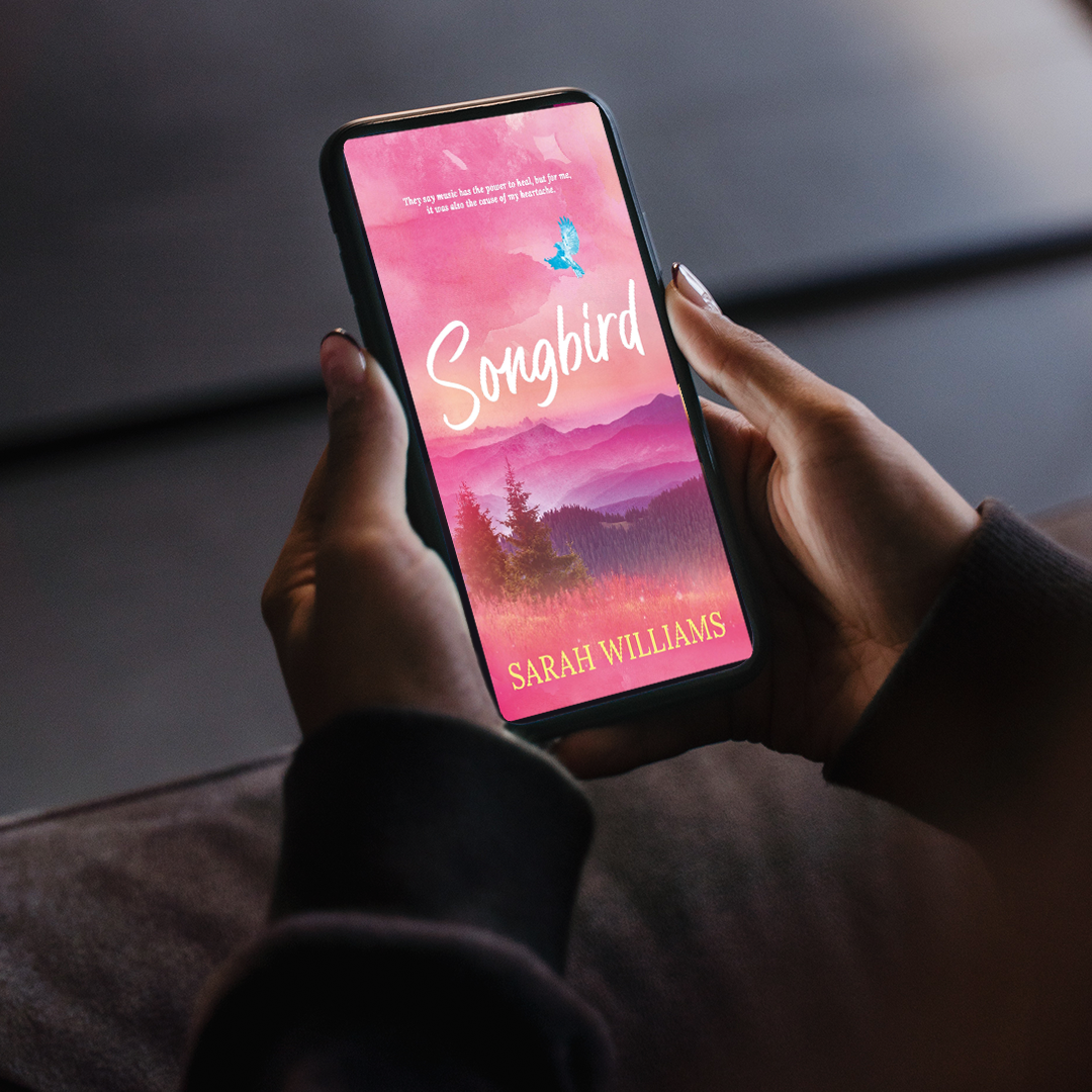 Person holding a smartphone with 'Songbird' by Sarah Williams displayed on the screen.