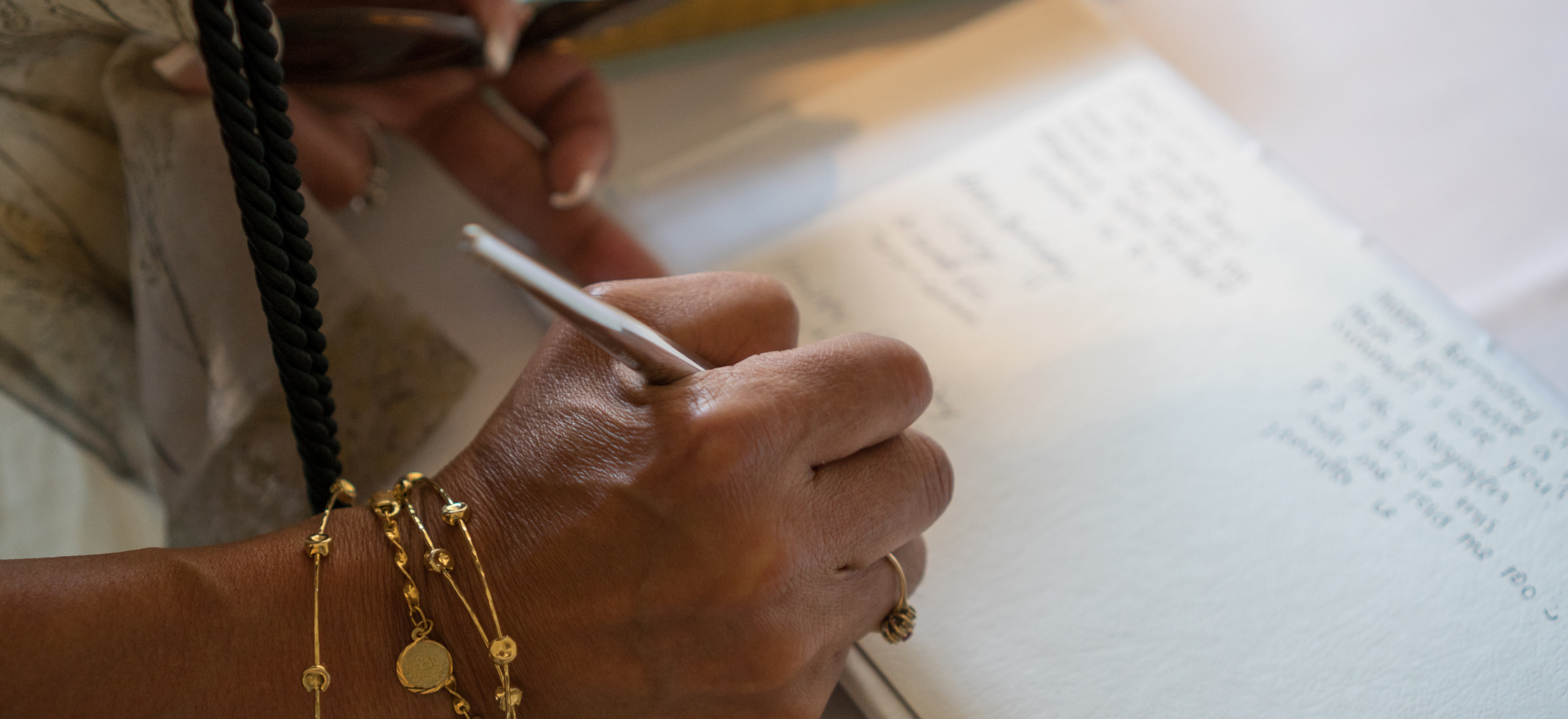 Close-up of hands writing with a pen on a document.