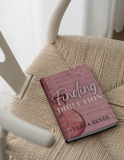 Book titled 'Finding Direction' by Tanya Renee on a woven chair