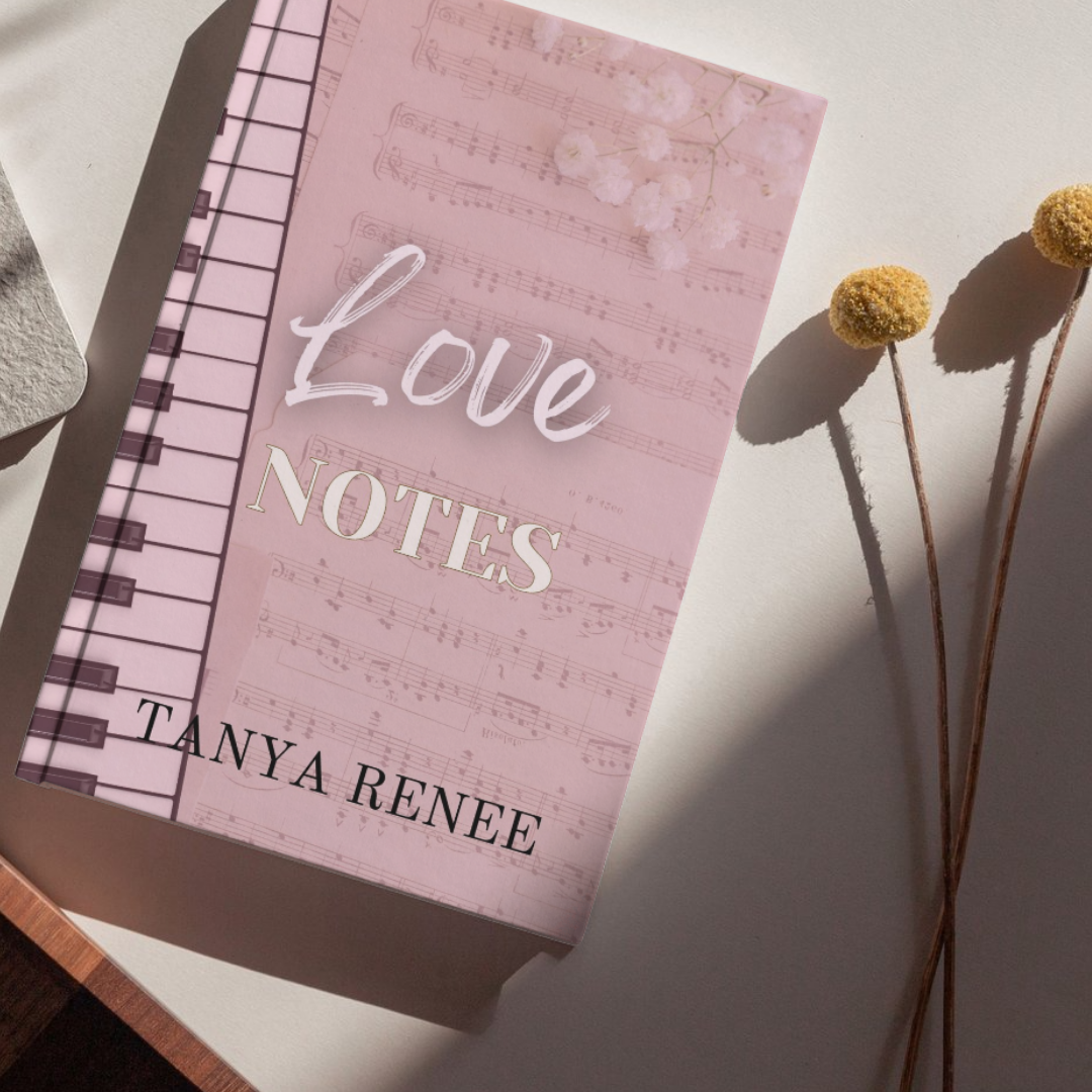 Pink notebook titled 'Love Notes' by Tanya Renee on a white surface with dried flowers.