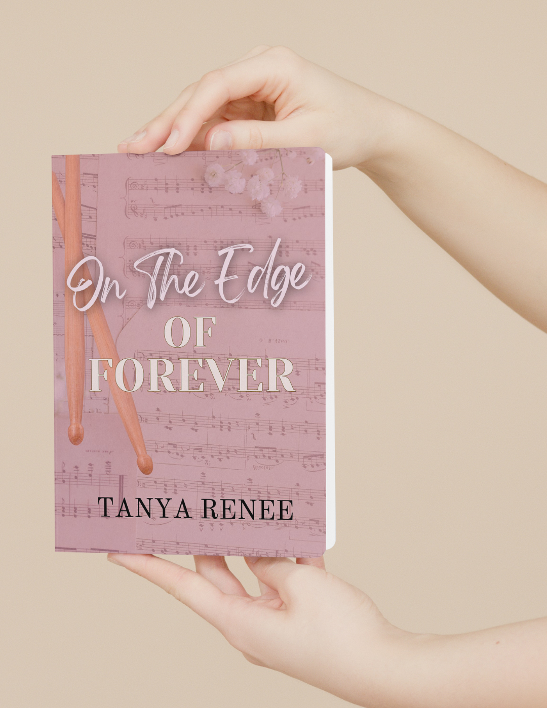 Book titled 'On The Edge Of Forever' by Tanya Renee held in hands against a beige background