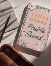 Book titled 'Prairie Sound' by Tanya Renee on a light surface with floral design