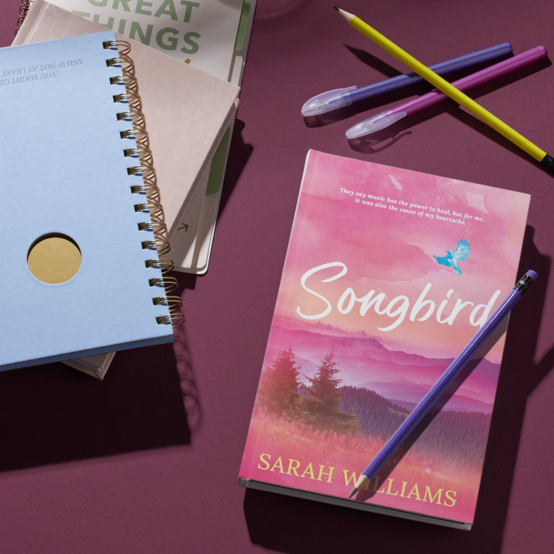 Book titled 'Songbird' by Sarah Williams with a pen on a purple surface