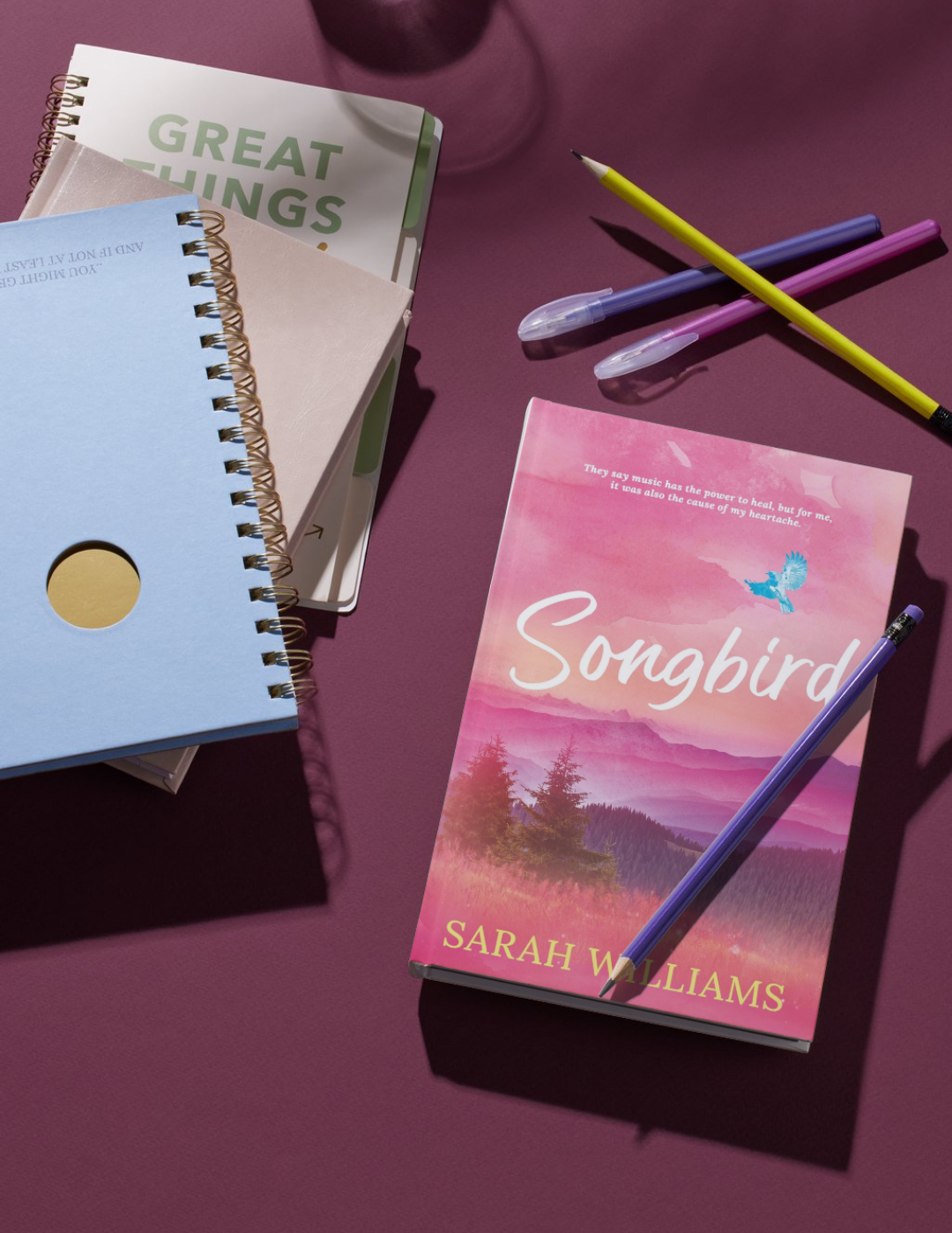 Book titled 'Songbird' by Sarah Williams with a pen on a purple surface