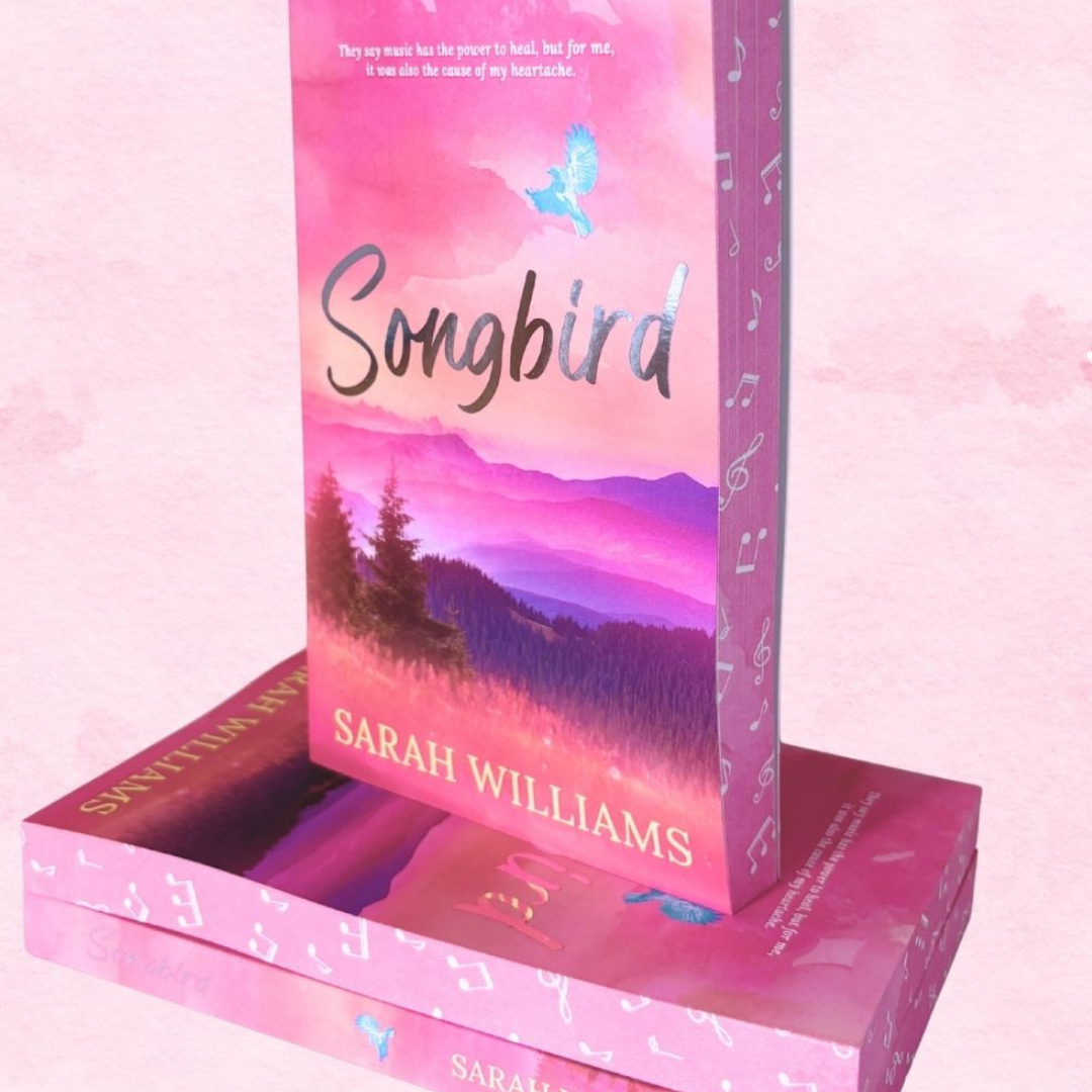 Book titled 'Songbird' by Sarah Williams with a pink and purple cover on a matching pink background.