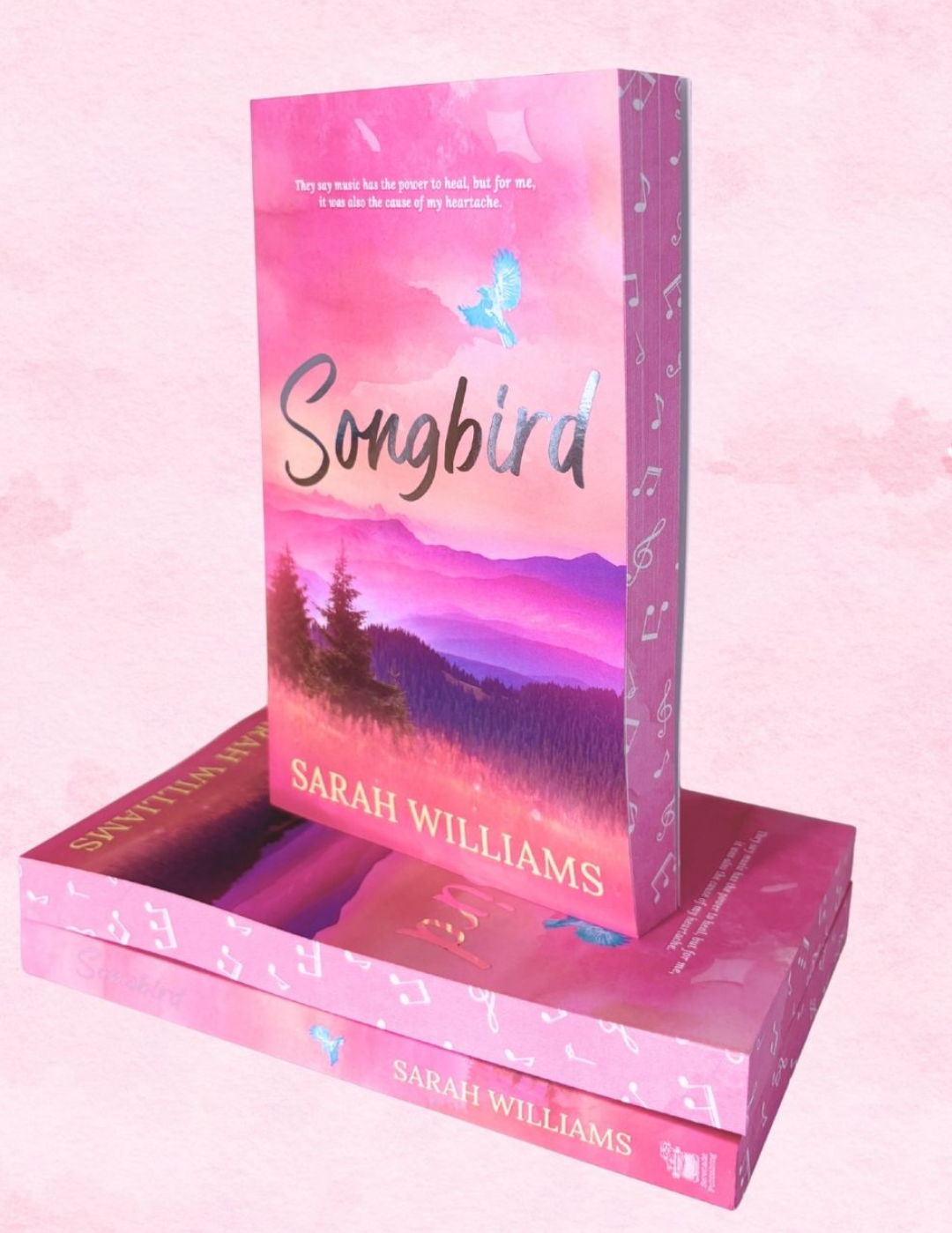Book titled 'Songbird' by Sarah Williams with a pink and purple cover on a matching pink background.