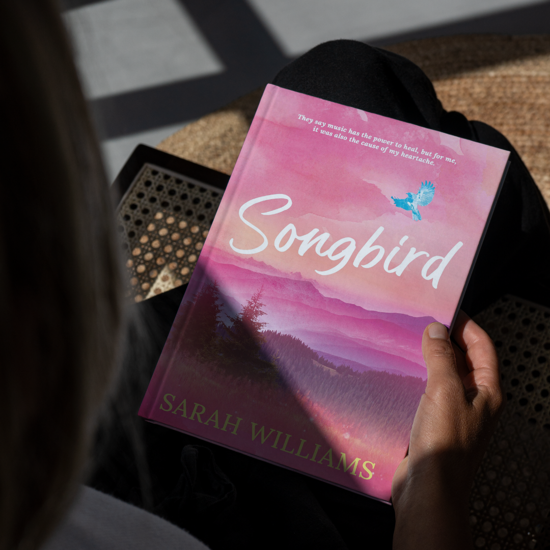 Book titled 'Songbird' by Sarah Williams held by a person.