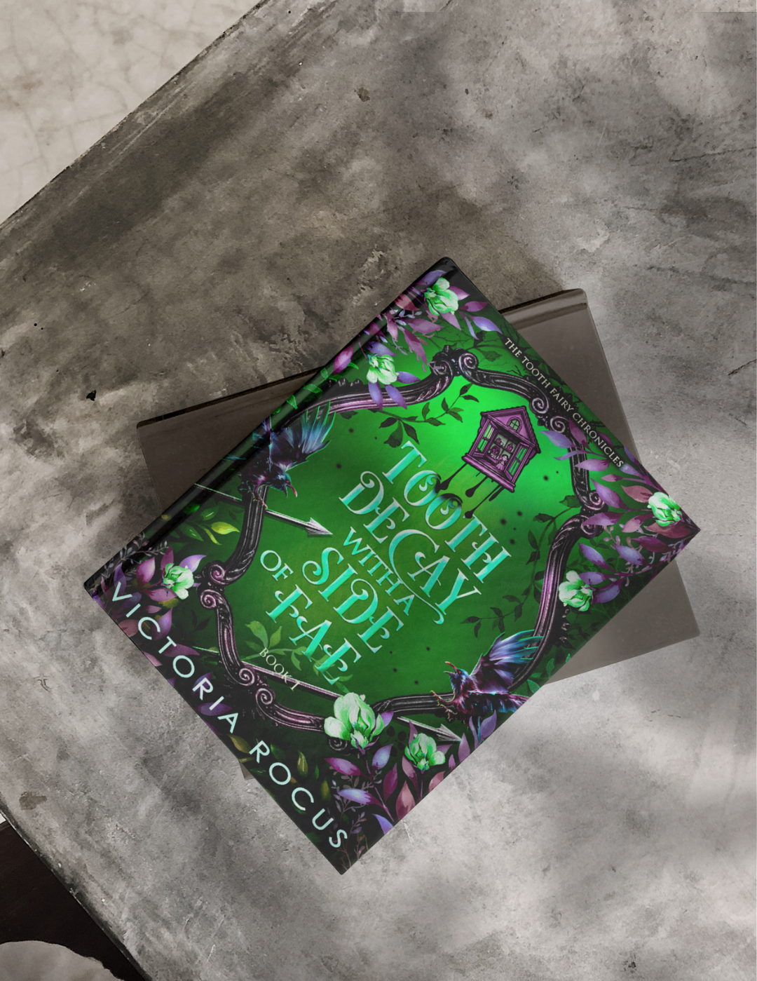 Book titled 'Tooth Decau with a Side of Fae' by Victoria Rogus on a textured surface