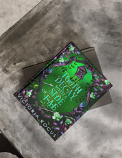 Book titled 'Tooth Decau with a Side of Fae' by Victoria Rogus on a textured surface