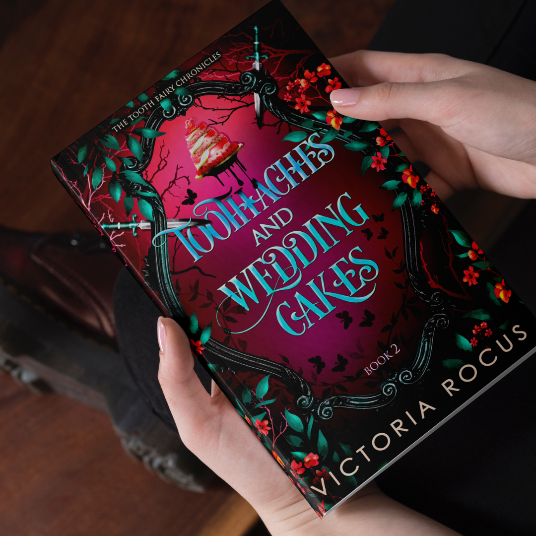 Book titled 'Toothaches and Wedding Cakes' by Victoria Rocus held by a person.