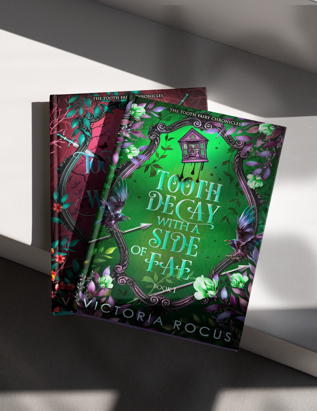 Two books titled 'Tooth Decay with a Side of Fae' and 'The Tooth Fairy Chronicles' by Victoria Rocus on a white surface.