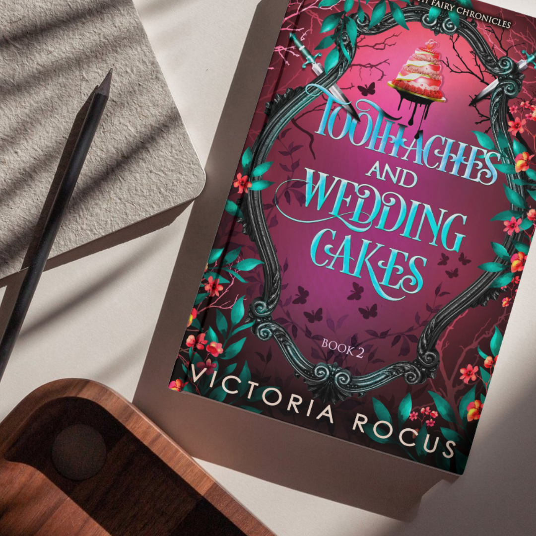 Book titled 'Toothaches and Wedding Cakes' by Victoria Rogus held by a person with water in the background